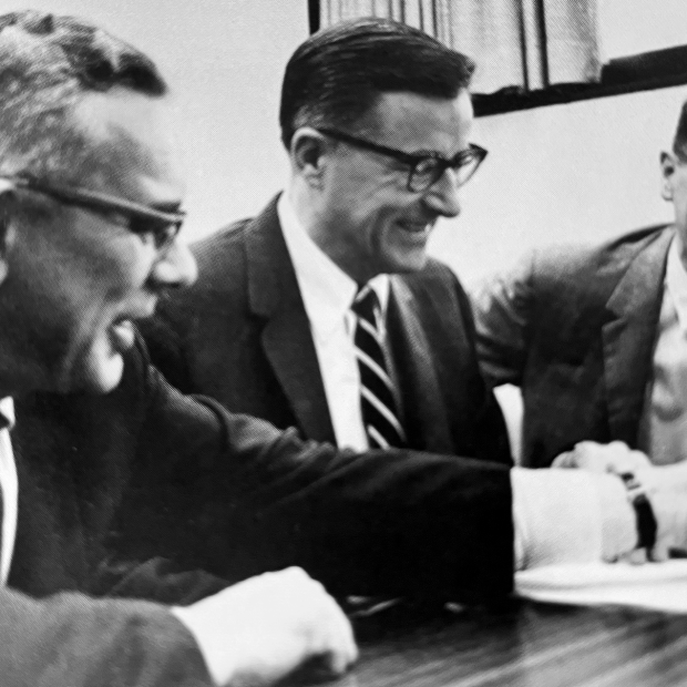 Howard Bowen at a table flanked by two men