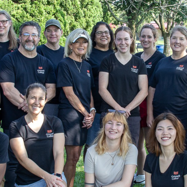 A group of enrollment professionals smile for the camera in matching black shirts