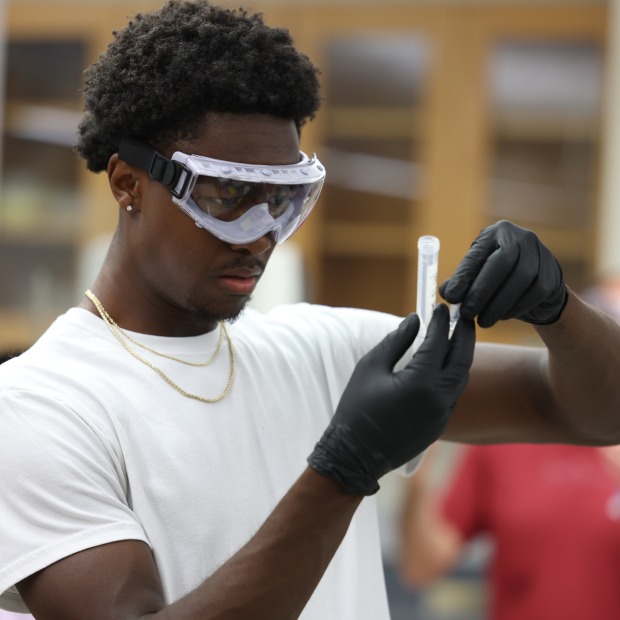 a man wearing goggles works in a lab
