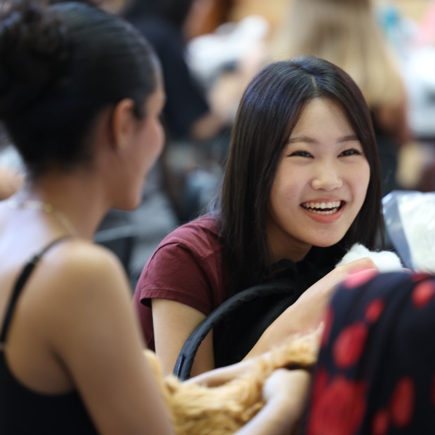 college students smile and speak at a table