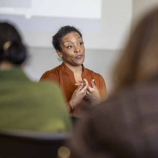 a person lectures at the front of a classroom