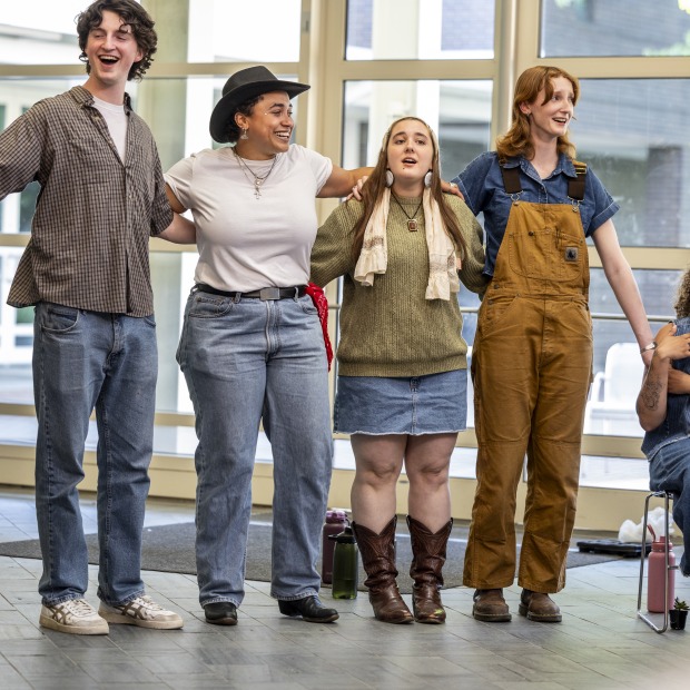 students stand with arms around each other's shoulders