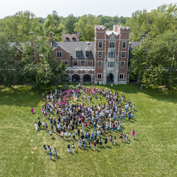 a large group of students gathers in front of Gates Tower