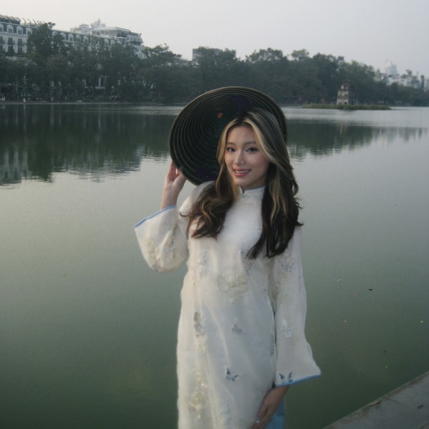 Nhi smiles at the photographer with a river in the background