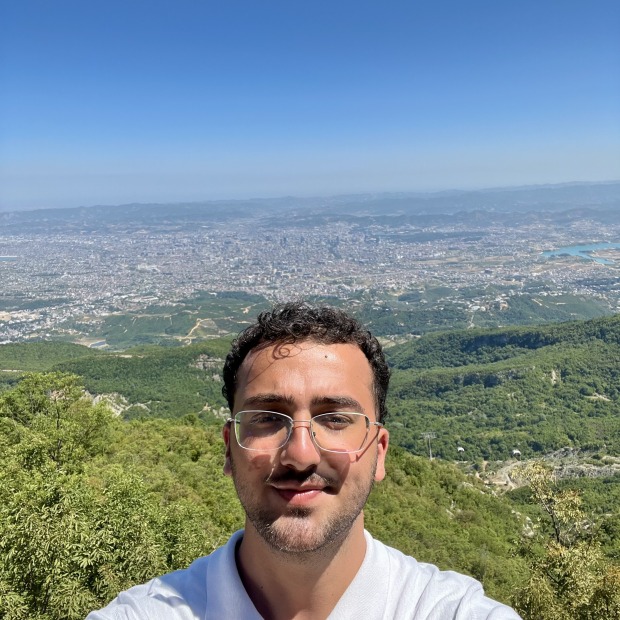 Drilon smiles at the camera overlooking a mountainous background