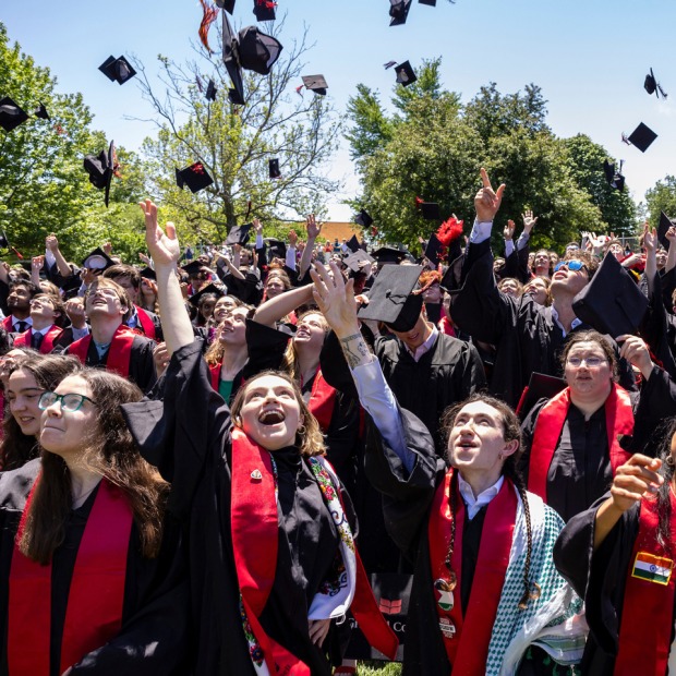 Grinnell graduates throw their graduation caps into the air at commencement