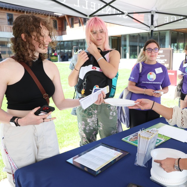 Excited new students at a check-in table during orientation
