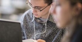 Student studying in Burling library with ear buds in