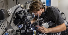 A young man manipulates equipment in a lab