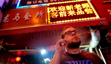 Student sampling Chinese food on a skewer