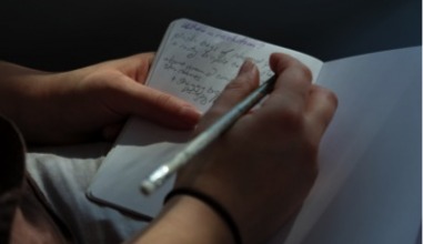 Student takes notes in notebook