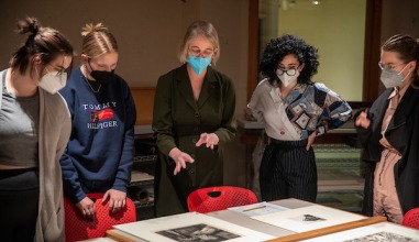 Professor and students examine art prints