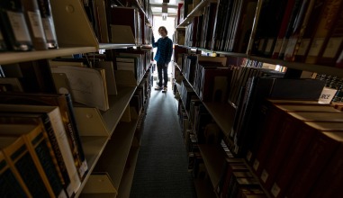 Daniel Rosenbloom stands in the library stacks surrounded by books