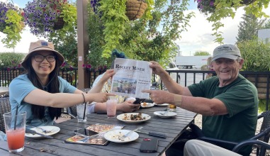 Professor Laura Ng and historian Dudley Gardner holding up the local Rocket Miner paper on which they were featured on the front page.
