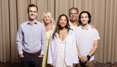 Kayla Figatner in a white doctor's coat with a small group of people.