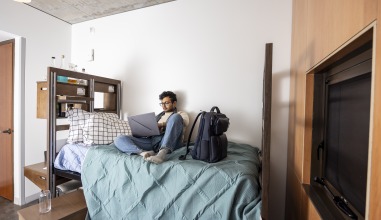Parikshit studies on his bed in his apartment in Renfrow Hall