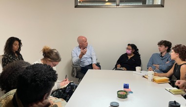 Students sit around a table meeting with Daniel Slager