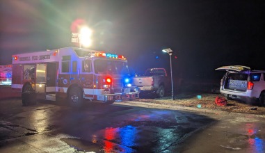 A fire engine with its lights on, illuminating the night