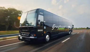 greyhound bus traveling down a road