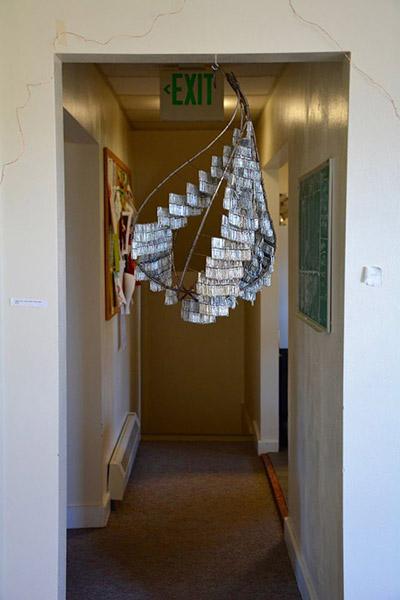 mobile art installation hangs in a hallway