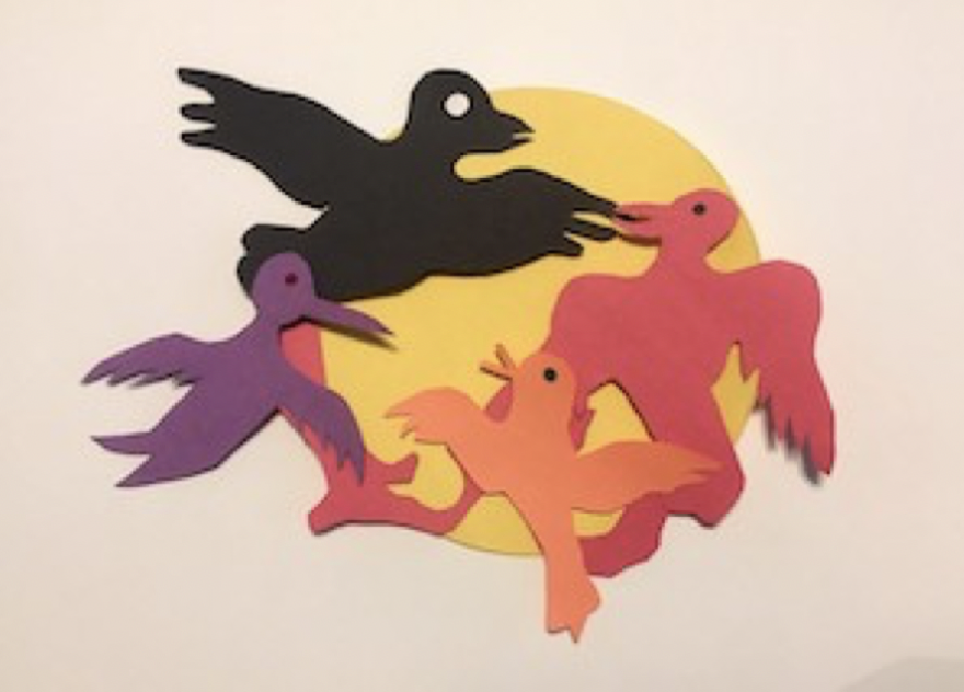 Alt text: Four birds flying over a yellow circle