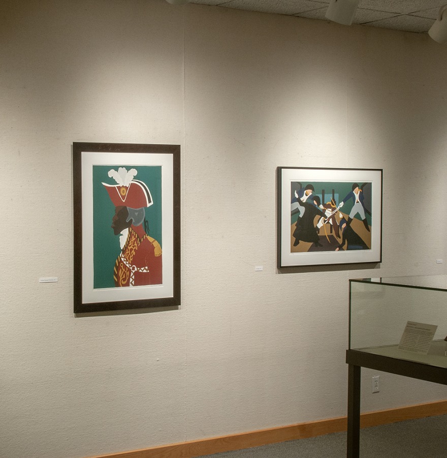 Installation view in Burling Library of two prints by Jacob Lawrence