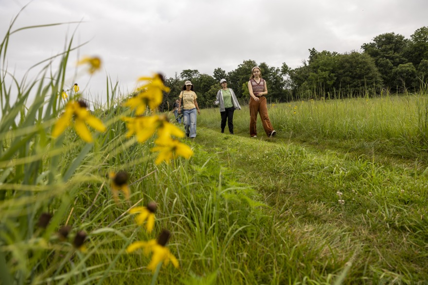 Bella Totten ’27 leading students to study site in the prairie of CERA