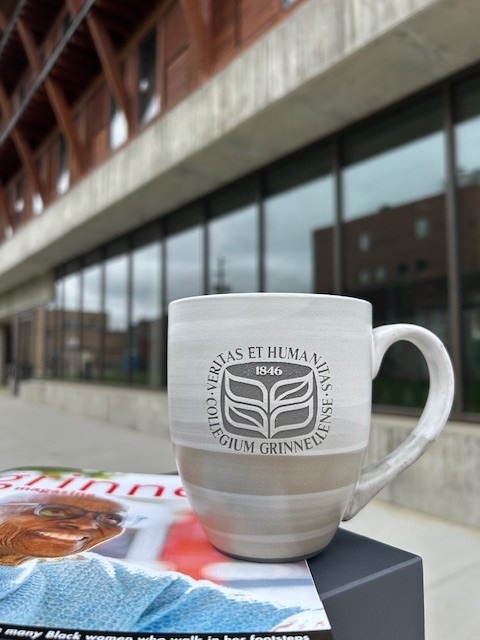 coffee cup on top of magazine in front of a building