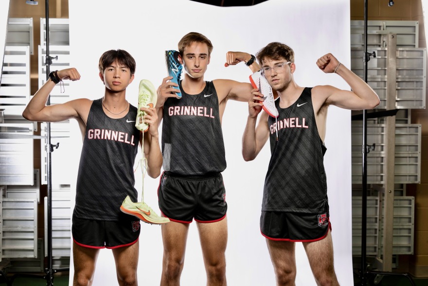 Three young men pose in cross country uniforms