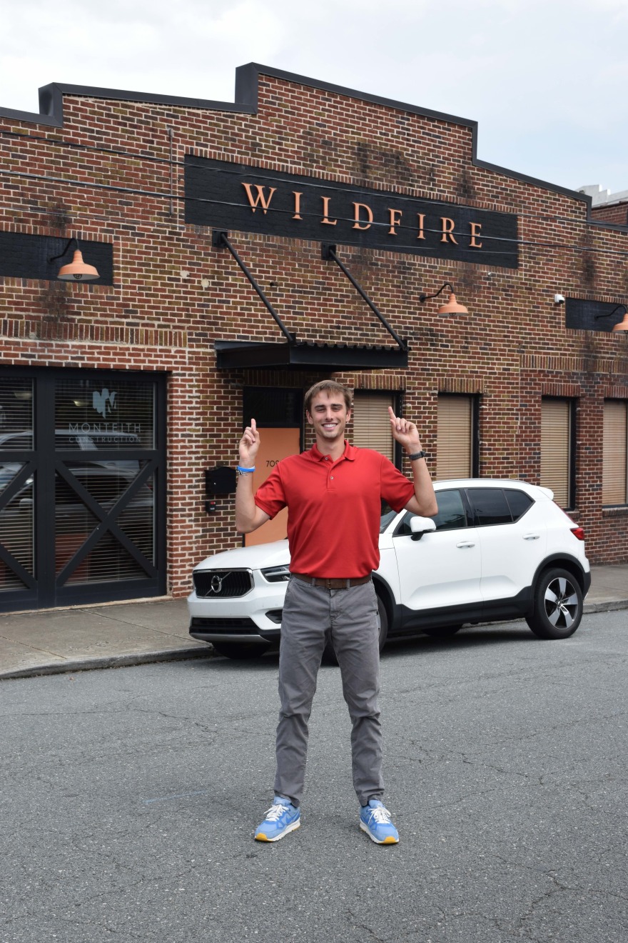 JAmes stands in the street in front the building where he did his internship