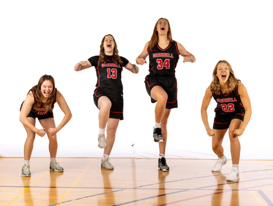 Four women basketball players pose for the camera