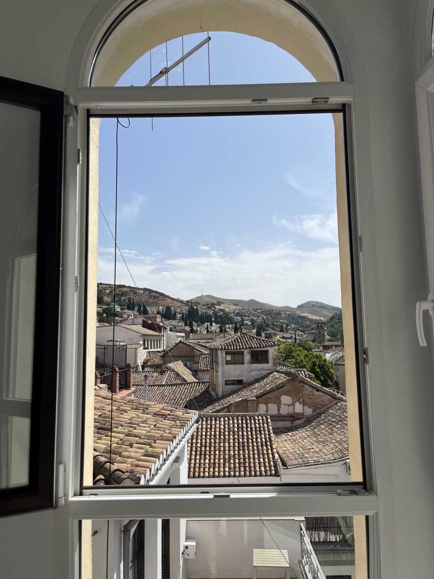 A view of the rooftops of Granada, Spain, through an open window