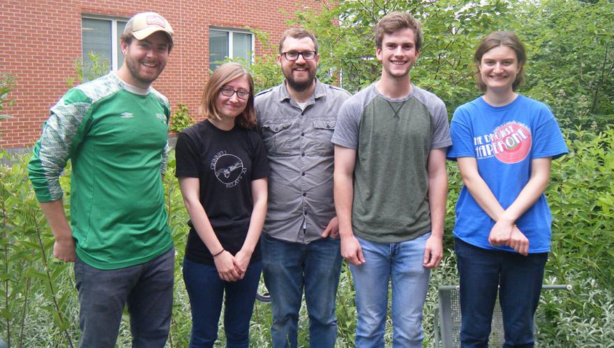 Four students and their faculty mentor outside the science building.
