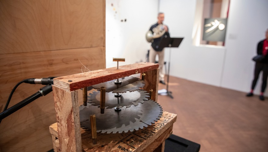 Eric McIntyre plays horn in the Faulconer Gallery with his dangerous instrument in the foreground