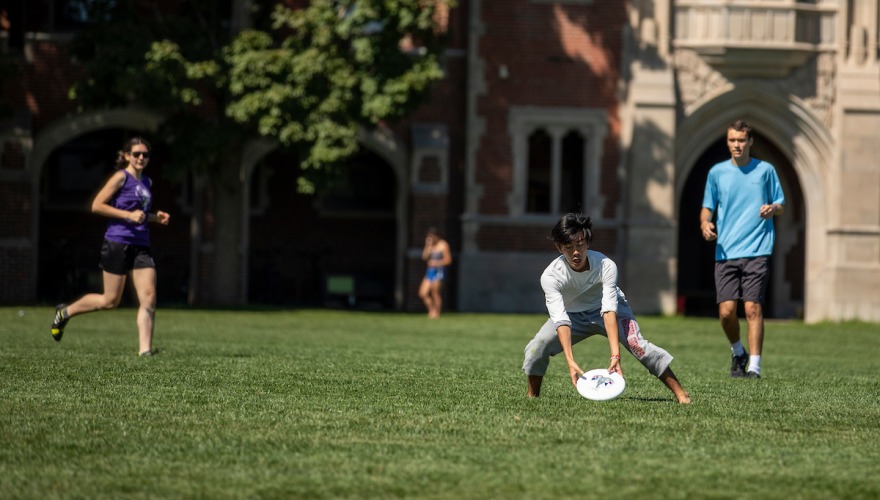 Students playing Ultimate on Mac Field, a large green space near college residence halls