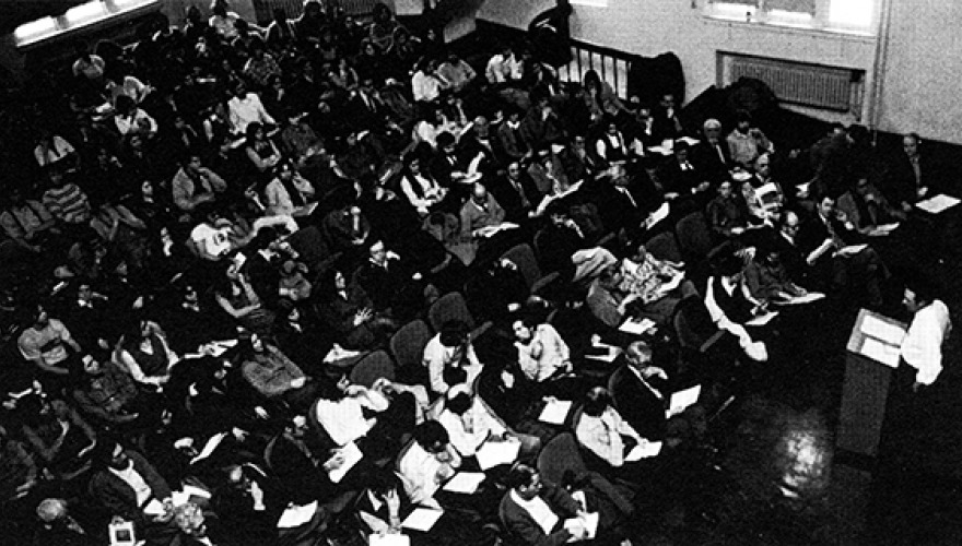 Black and white bird's eye view of ARH auditorium filled with people