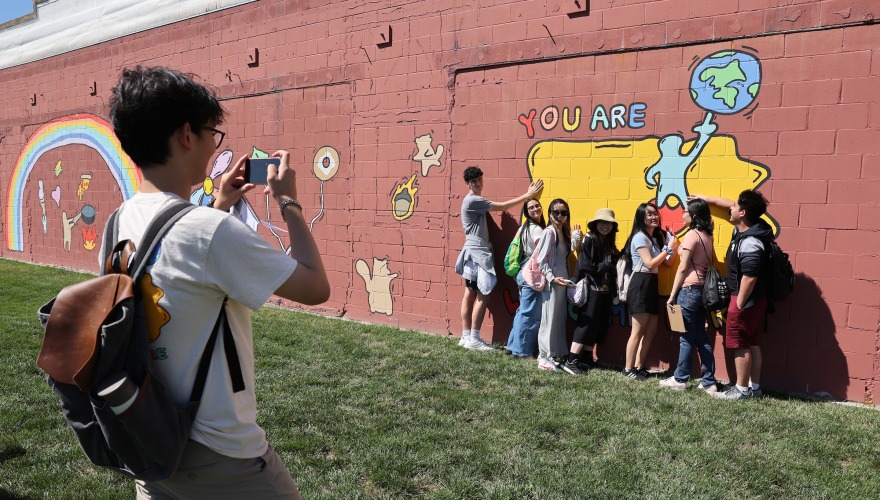 Students standing by mural 