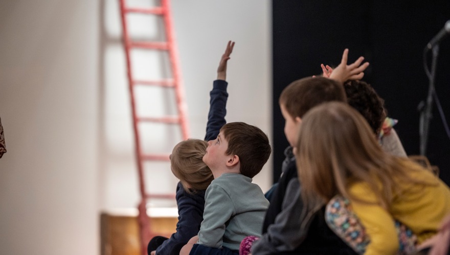 young children looking up at art 