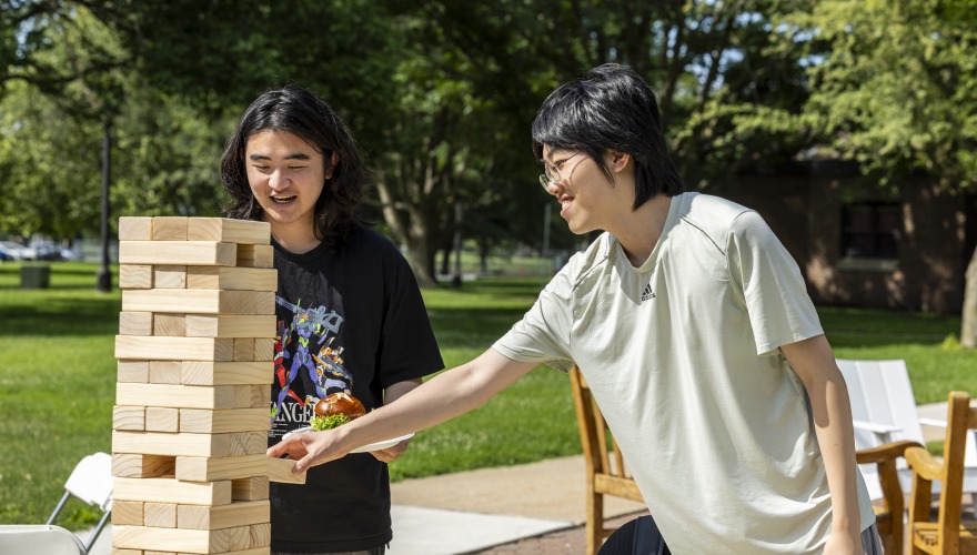 2 students playing Jenga outside