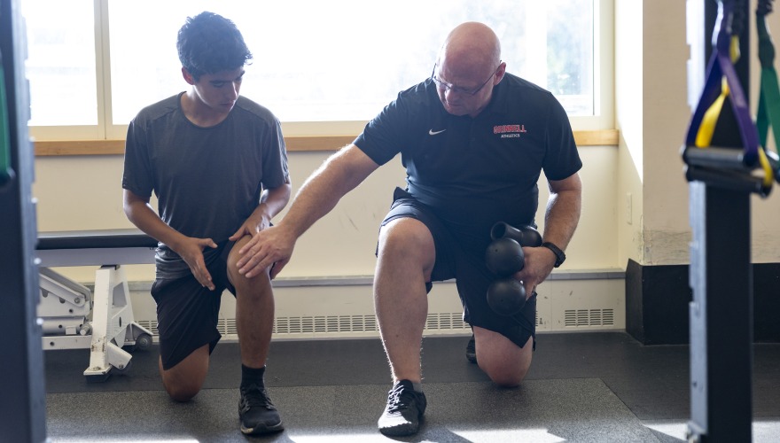 Strength coach Steve Lewis shows an athlete proper form.