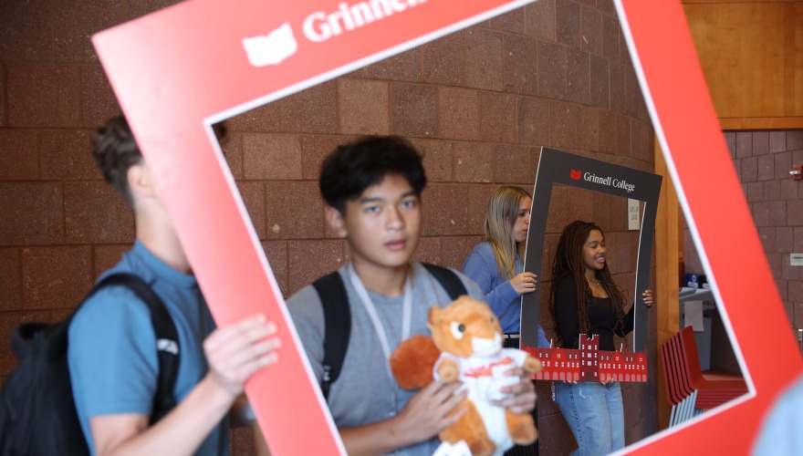 Four students hold black and red frames around themselves.