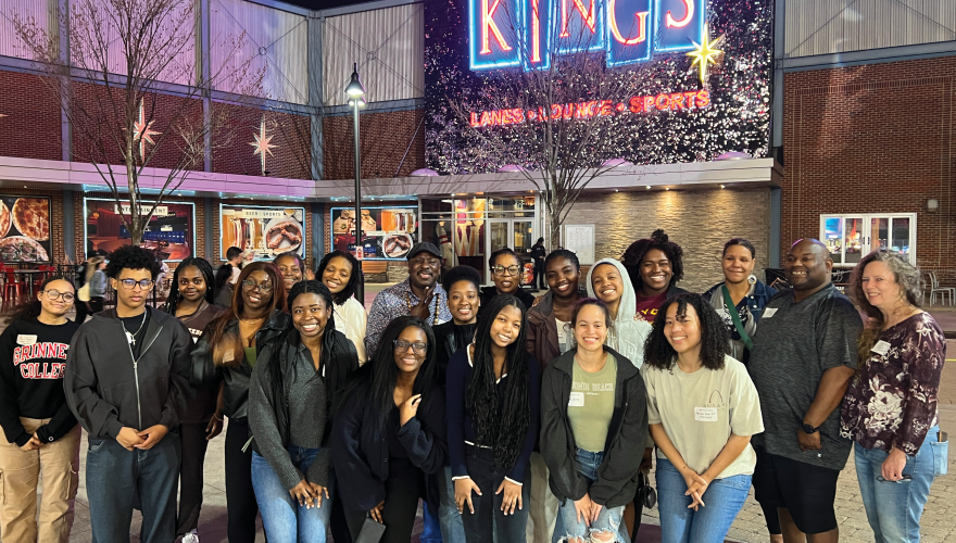 Group of alumni outside a restaurant at night