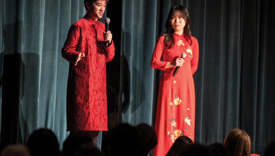 Nam Do and another student on stage. Both are dressed in red.