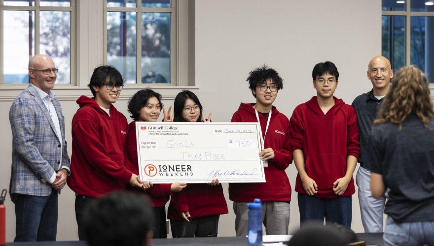 Judges and students standing with large check for 3rd place