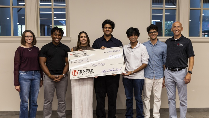 Students standing with a large check for first place