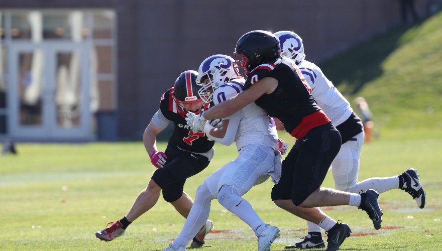 Grinnel football player tackles an opponent 
