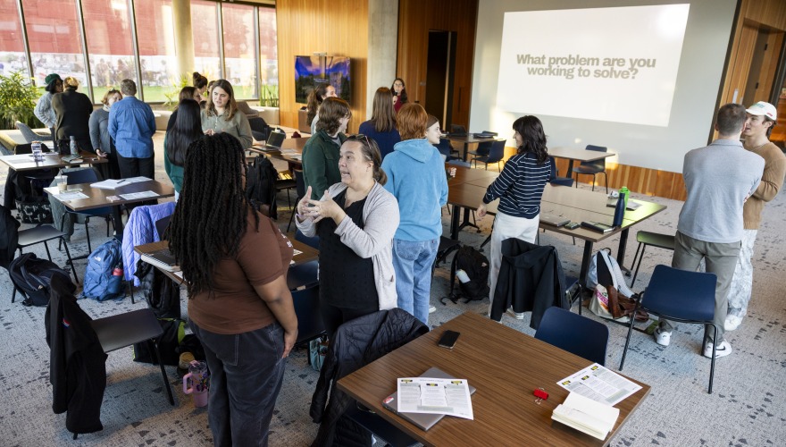 Small groups of people talk and gesture in the Weingart Pavilion