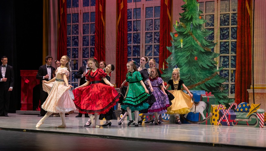 little girls performing in the nutcracker on stage in dresses 