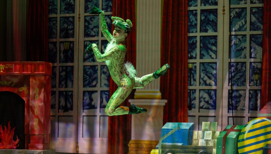 man dressed in green dancing on stage