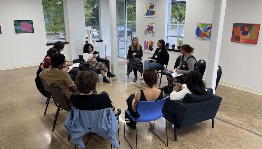Students sit around a table with their host at the Interact Center